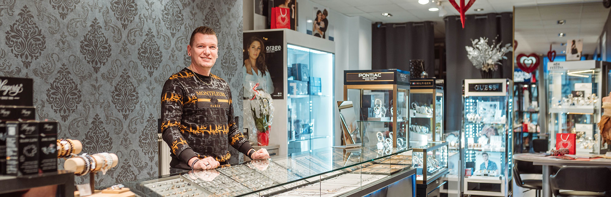 Portret van Kevin achter zijn toonbank in zijn juwelenzaak.