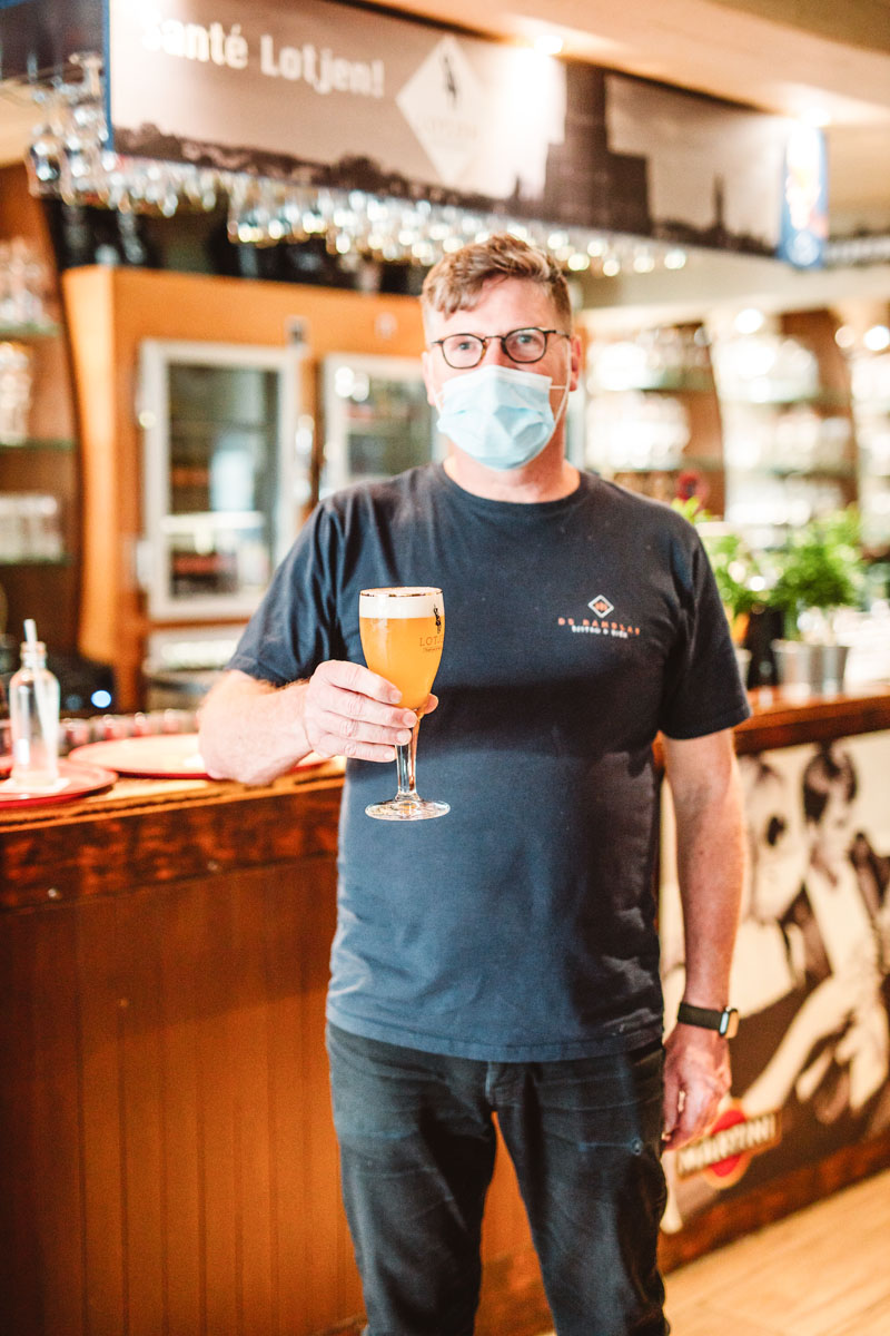 Eddy toont een lotjen. Deze foto's zijn genomen tijdens het Corona tijdperk dus Eddy draagt een mondmasker.