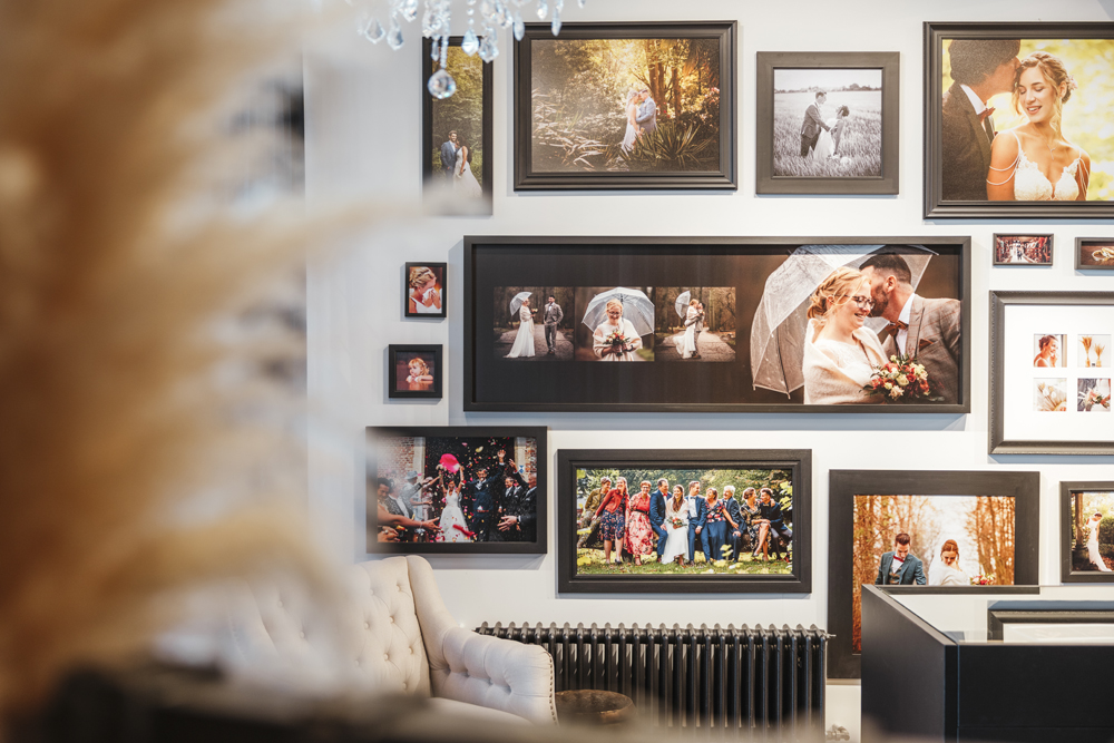 Vergauwe-Eeklove-16 Een 10-tal fotokaders met huwelijksfoto's hangen op de muur.