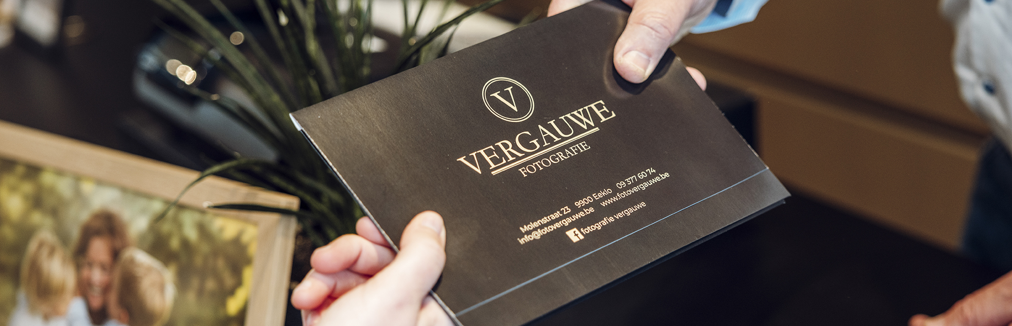 Vergauwe-Eeklove-41 Close-up van het foto mapje met pasfoto's van Fotografie Vergauwe wordt aan de klant afgegeven
