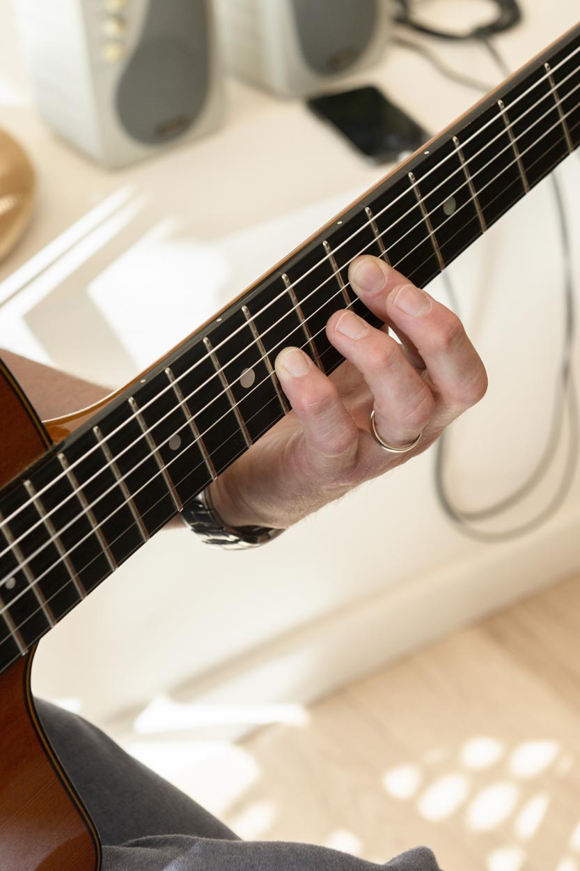 Eeklove-Dolly Dagger-8 Hand die een akkoord op een gitaar doet.
